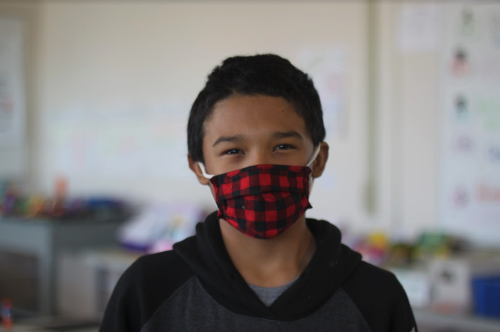 Student in mask smiling at the camera